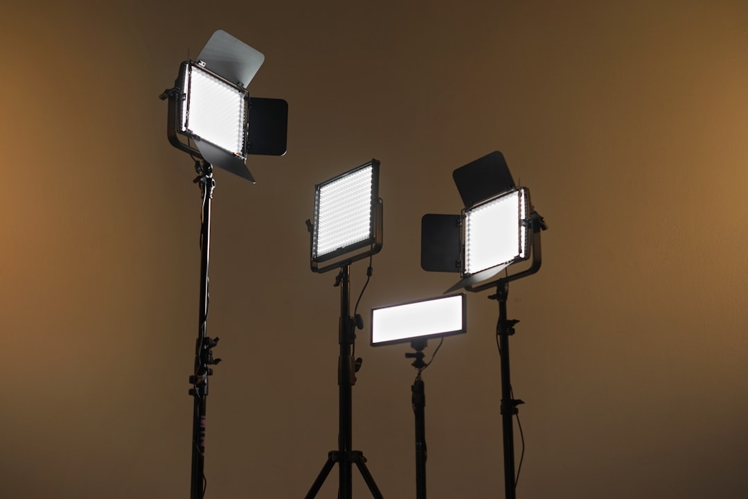 Three studio LED panels on light stands against a warm brown backdrop, ready for a photo shoot.