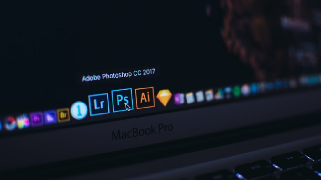 Close-up of a MacBook Pro dock showing the Adobe Photoshop CC 2017 icon highlighted, with Lightroom and Illustrator icons nearby.