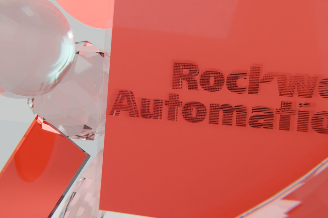 Close-up of a red-orange sign with the words 'Rockwell Automation' partially visible.