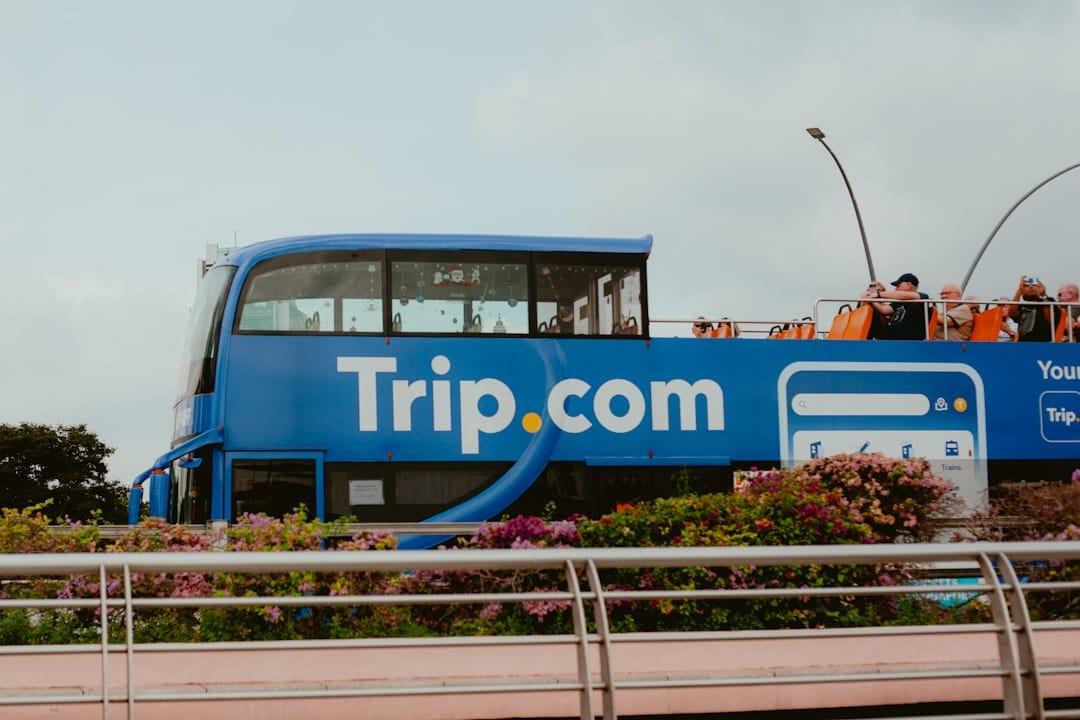 A blue double decker bus driving down a street bus ticket booking web app interface mobile booking - AI Bud