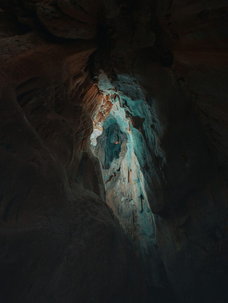 a close up of a mountain lava cave shadowy platforms glowing background - AI Bud