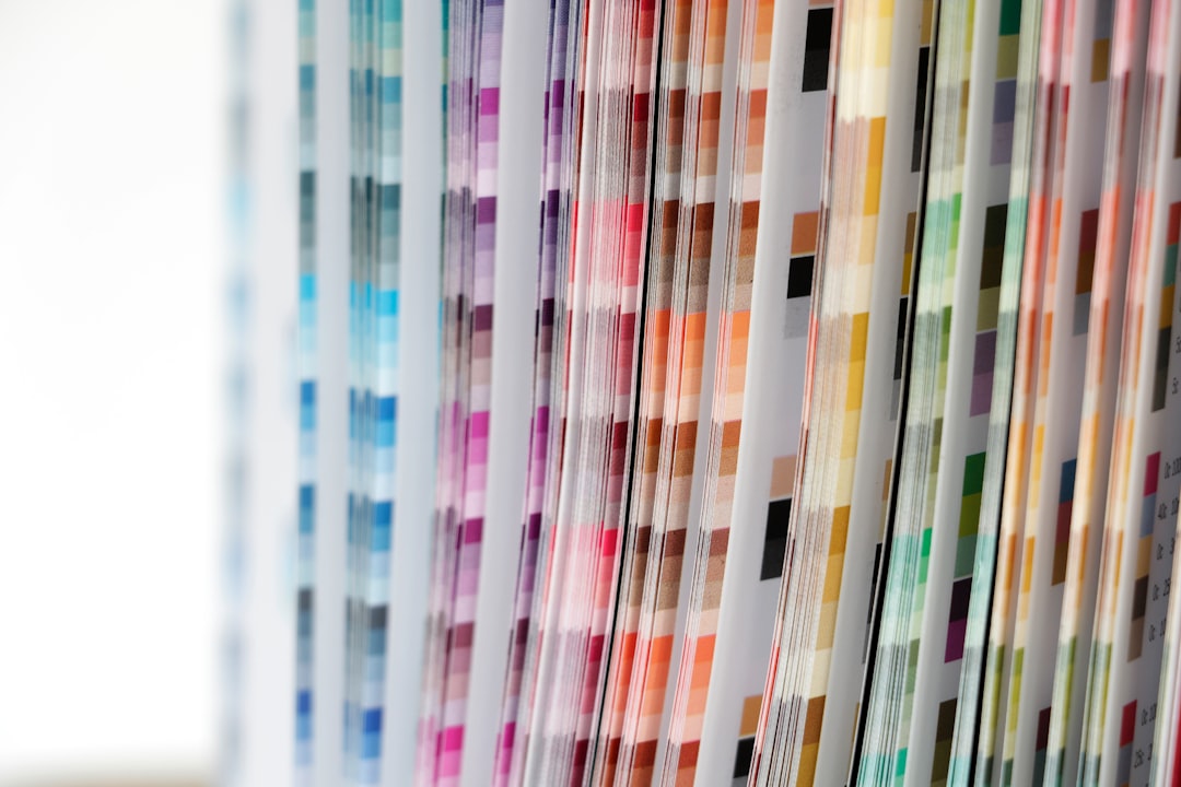 Row of color swatch cards arranged by hue, forming a rainbow of pigment samples.