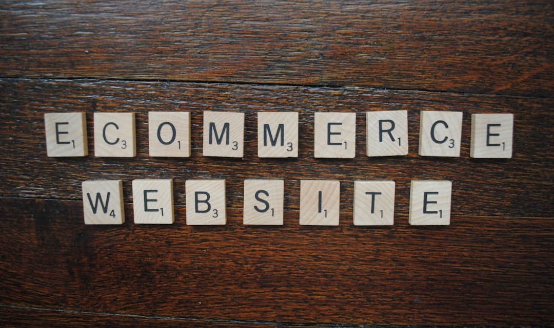 Wooden scrabble tiles spell 'ECOMMERCE' above and 'WEBSITE' below on a dark wooden surface.
