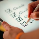 Person uses a stylus to check off items on a digital to-do list on a tablet.