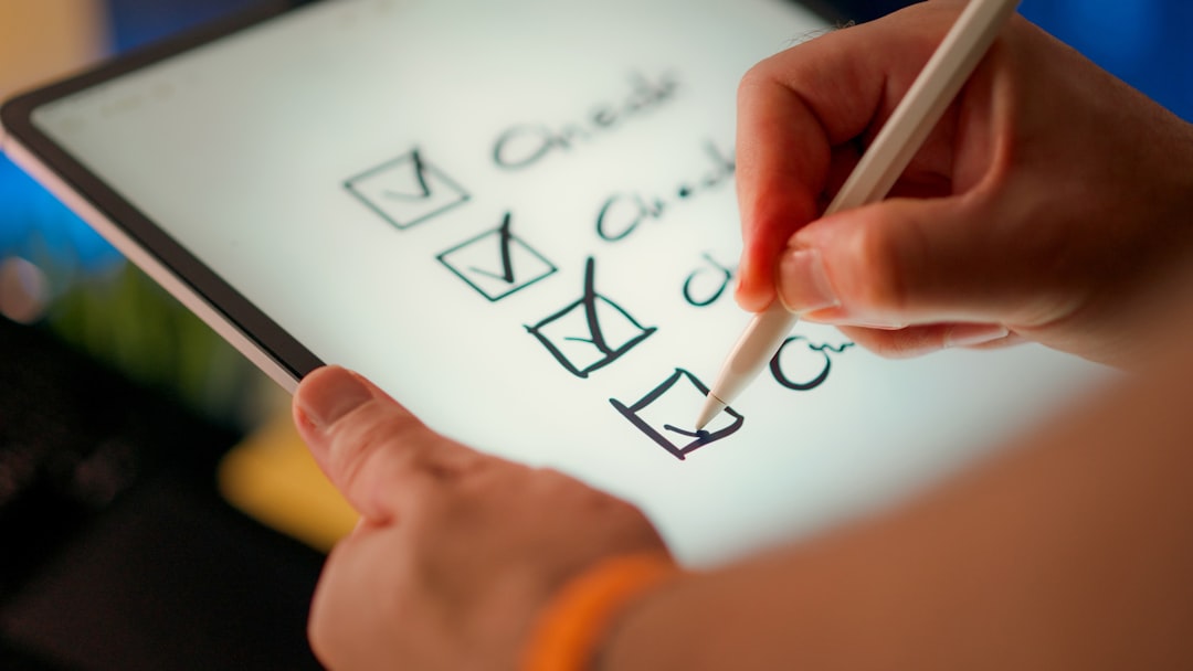 Person uses a stylus to check off items on a digital to-do list on a tablet.