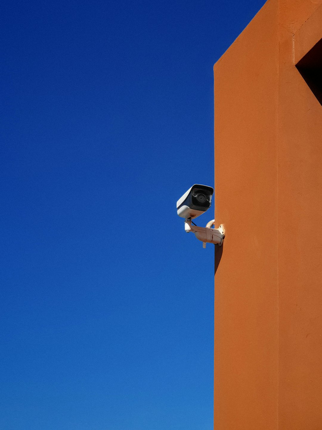 a security camera attached to the side of a building system audit access control security architecture - AI Bud