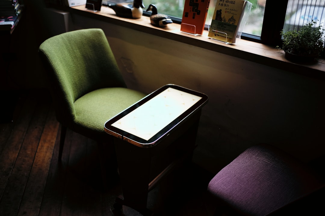 green chair in front of table near window restaurant pos touchscreen staff using pos - AI Bud