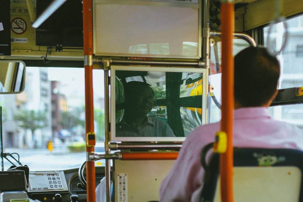 person in pink shirt sitting inside train bus ticket booking web app interface mobile booking - AI Bud