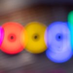 Blurred multicolor Google logo letters formed by glowing circles.