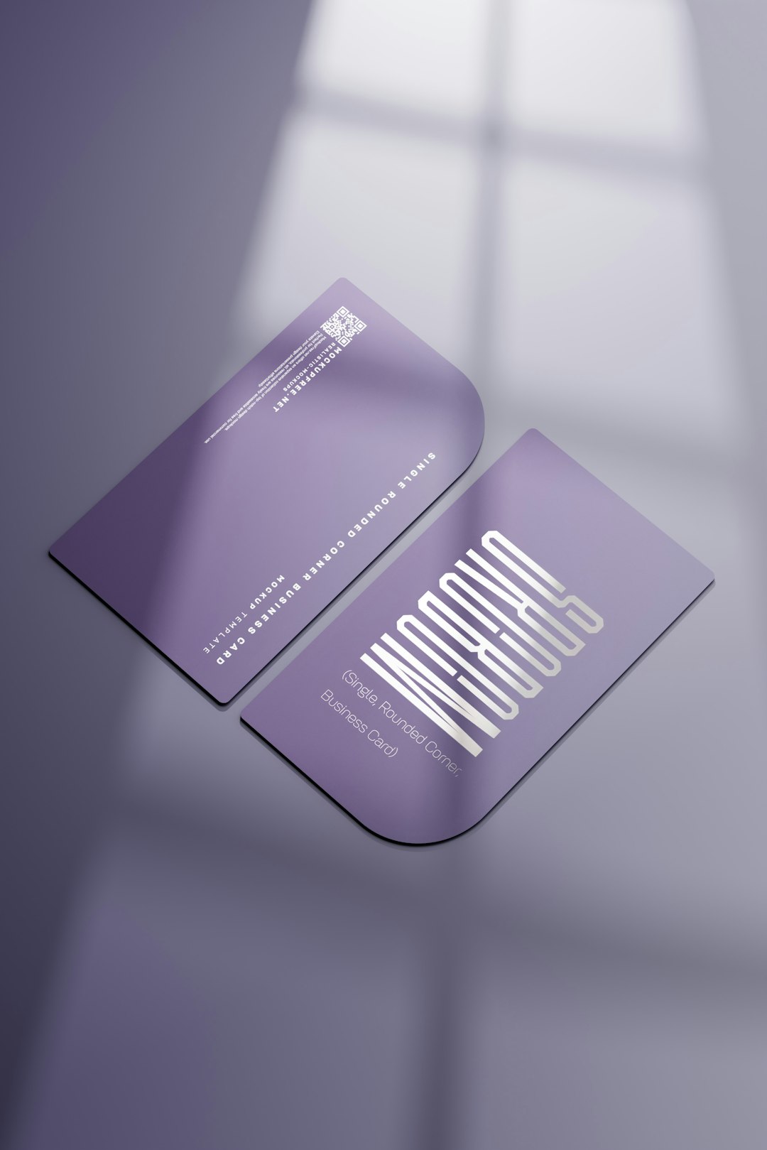 Two purple business cards with rounded corners resting on a soft purple surface, one showing a white geometric logo and small text edge.