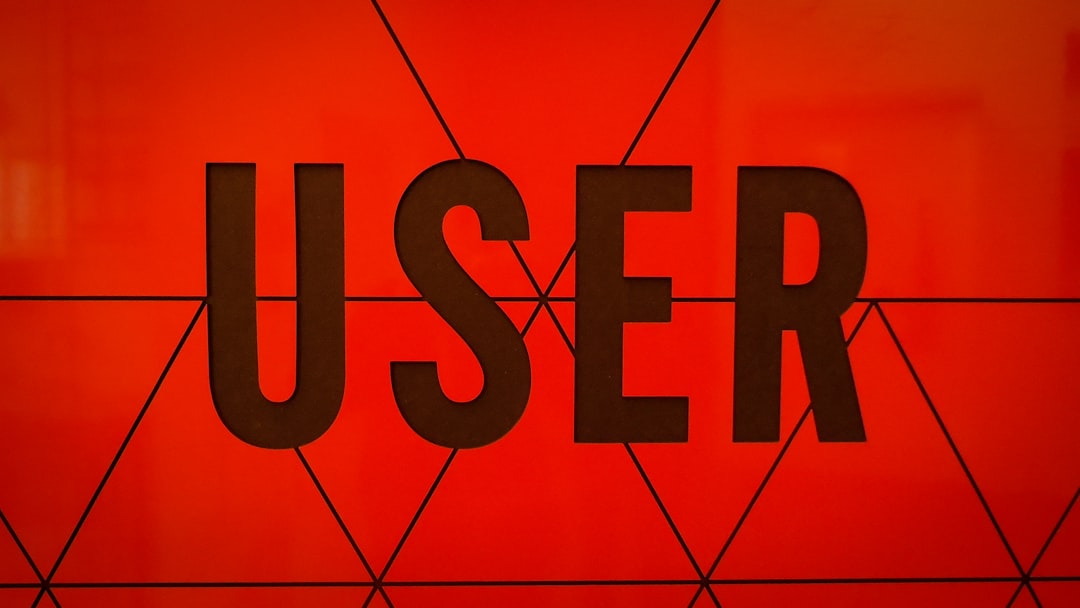Bold black word 'USER' on an orange background with a geometric line pattern of triangles crossing the text