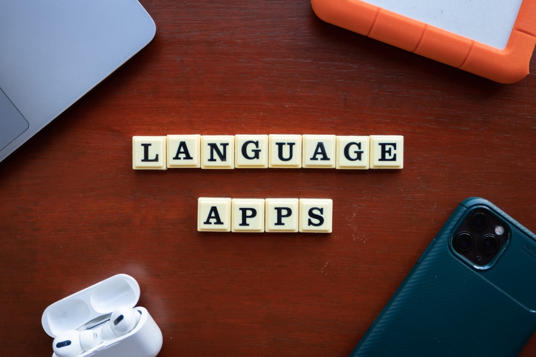 a wooden table topped with a cell phone and two scrabble tiles translation process language selection site builder - AI Bud