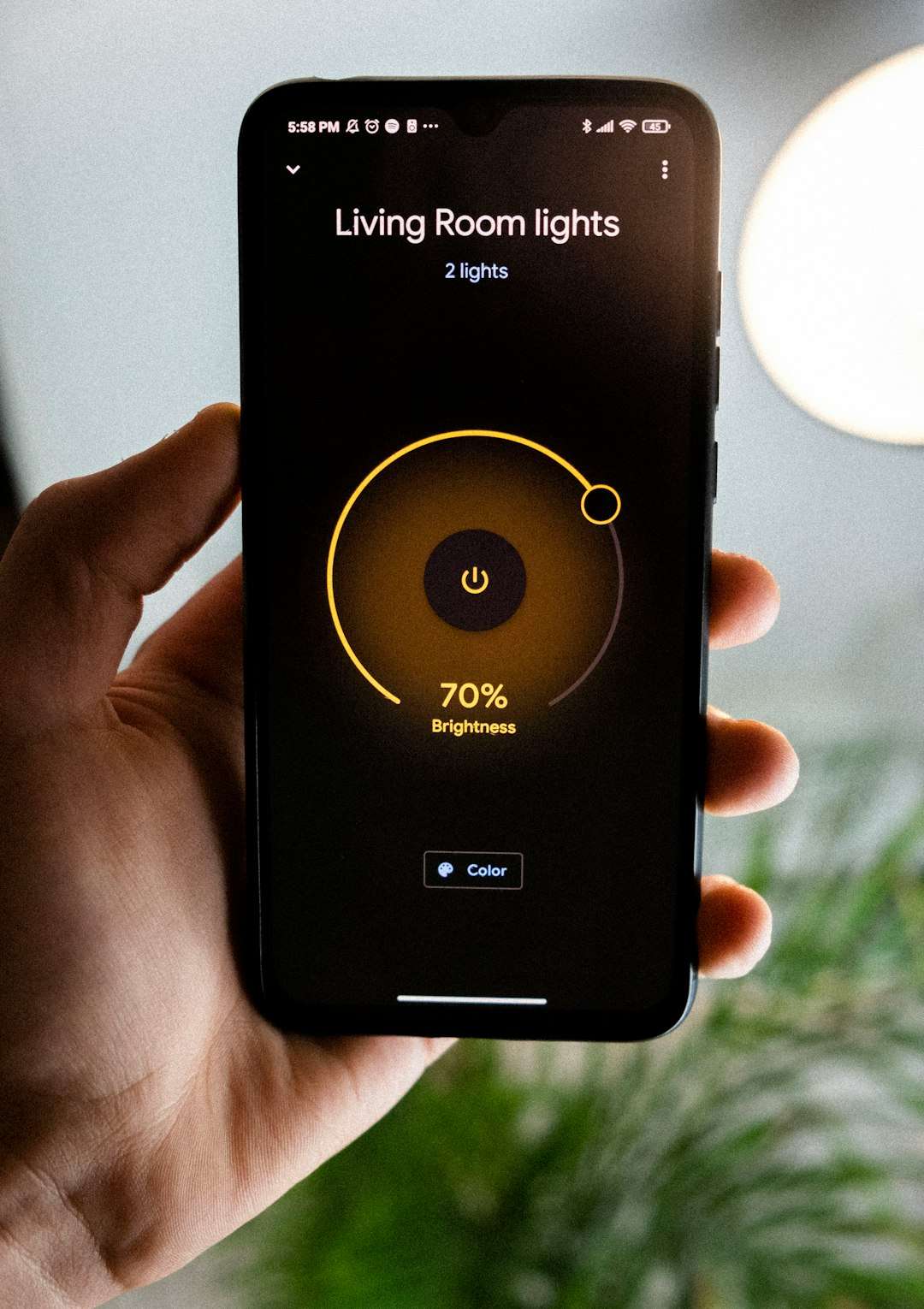 Smart home app on a phone showing Living Room lights with 2 lights and a circular brightness control at 70%.