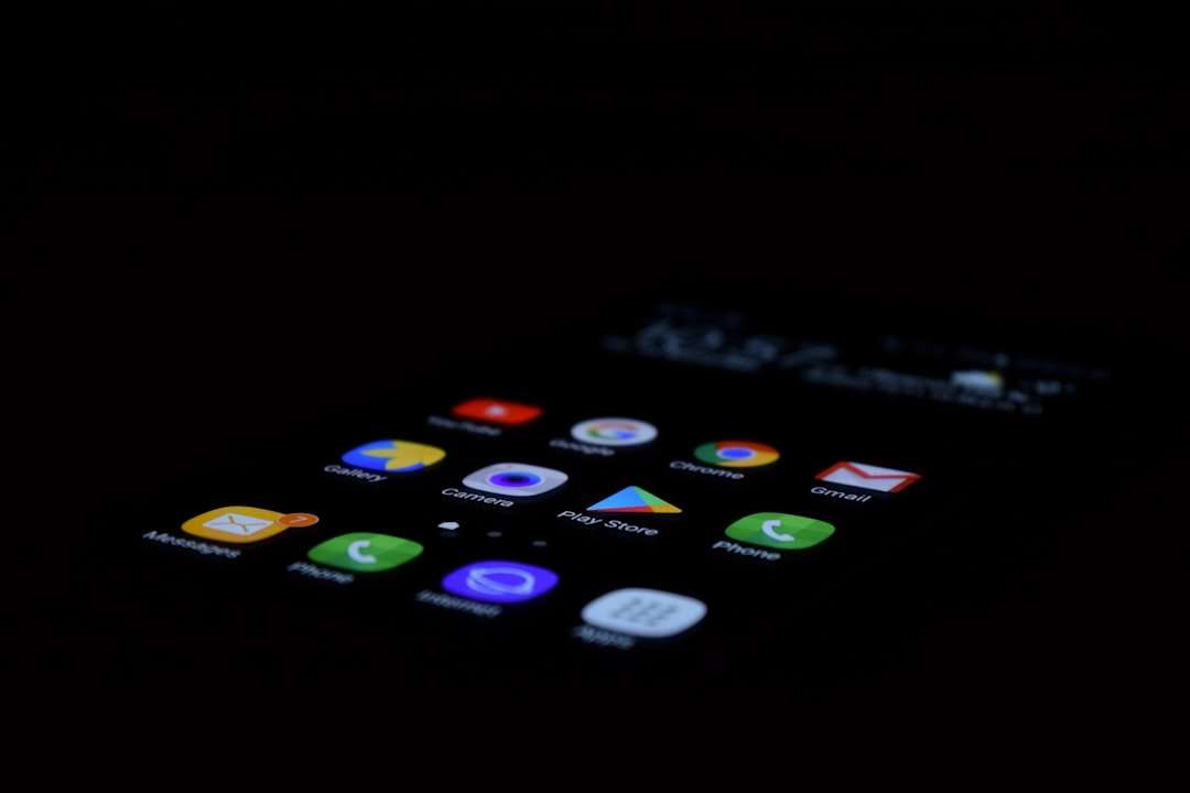 Close-up of a smartphone home screen in low light, showing colorful app icons like Messages, Phone, Chrome and Gmail on a dark background.