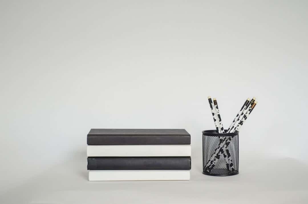 A black and white desk with a pen holder and two pencils ai scribe digital notebook intelligent automation - AI Bud