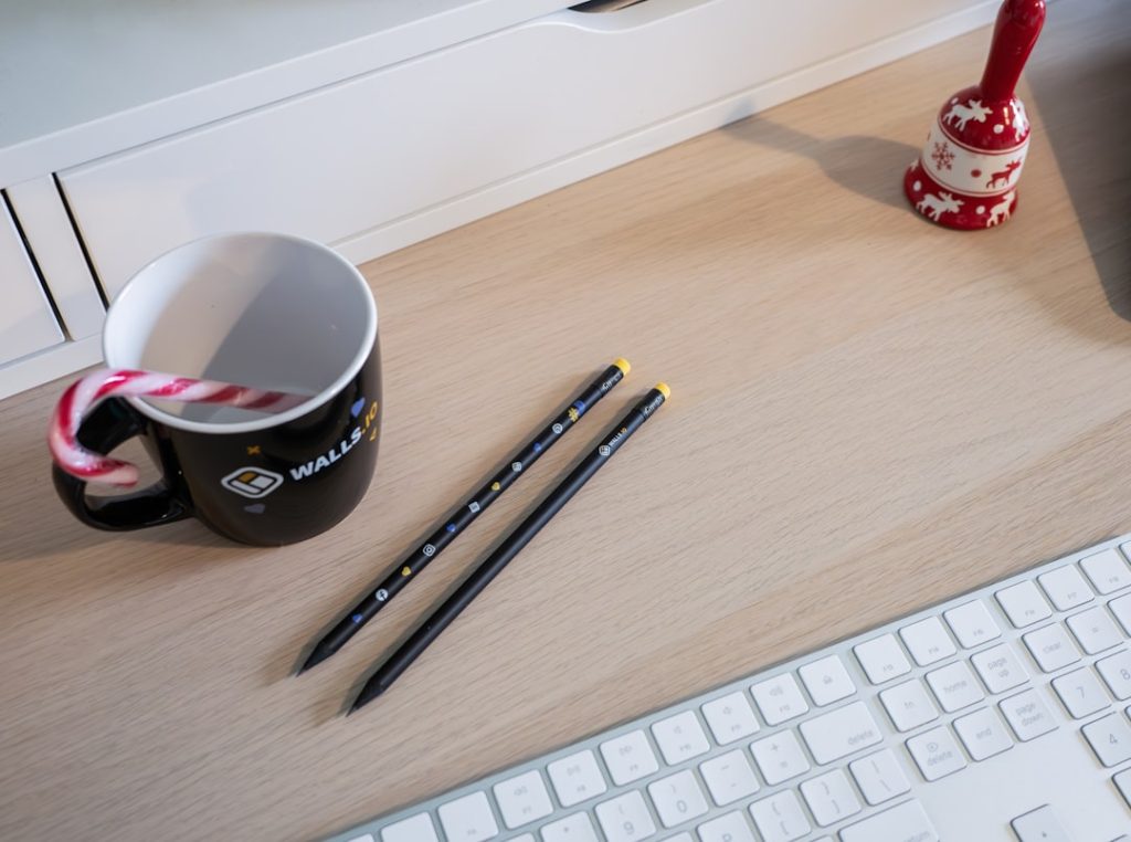 a cup of coffee and two pencils on a desk writer desk blog content digital marketing tools - AI Bud
