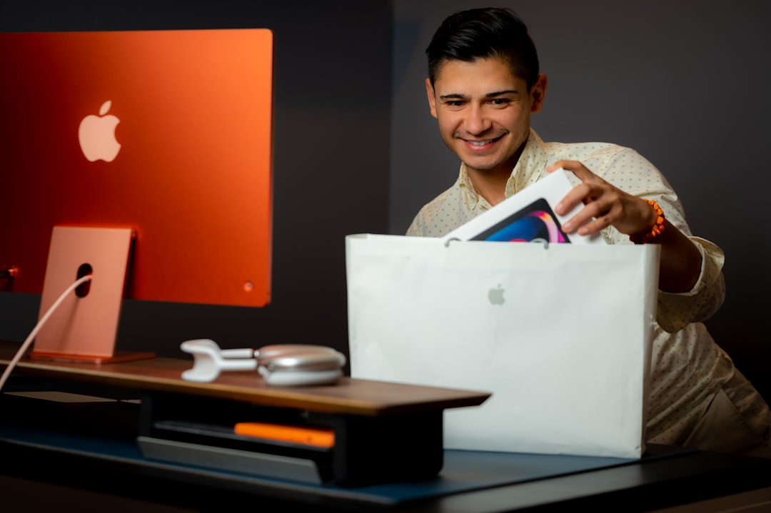 a man sitting at a desk with a bag and a computer happy customer online savings laptop upgrade - AI Bud