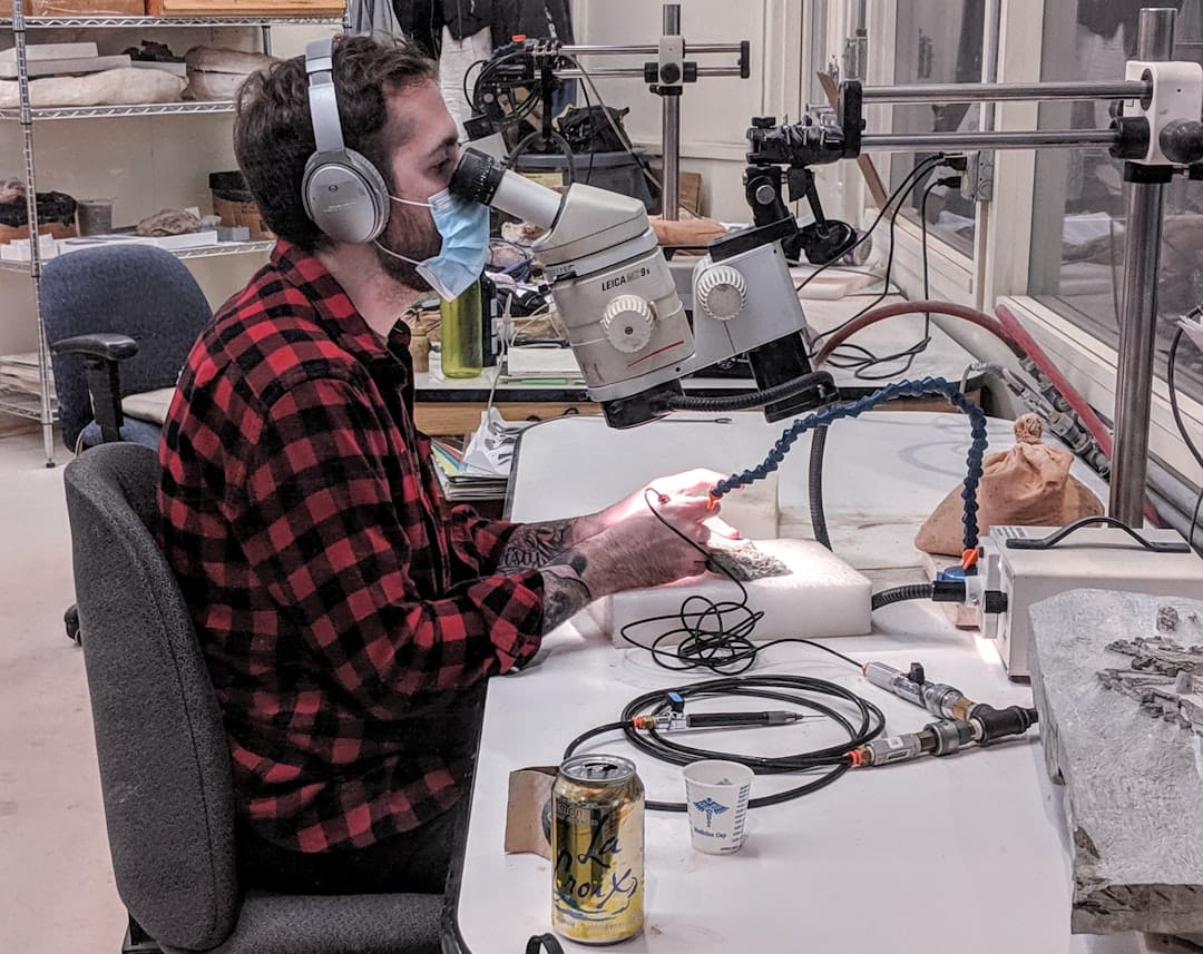 man looking in microscope students diversity science lab podcast discussion - AI Bud