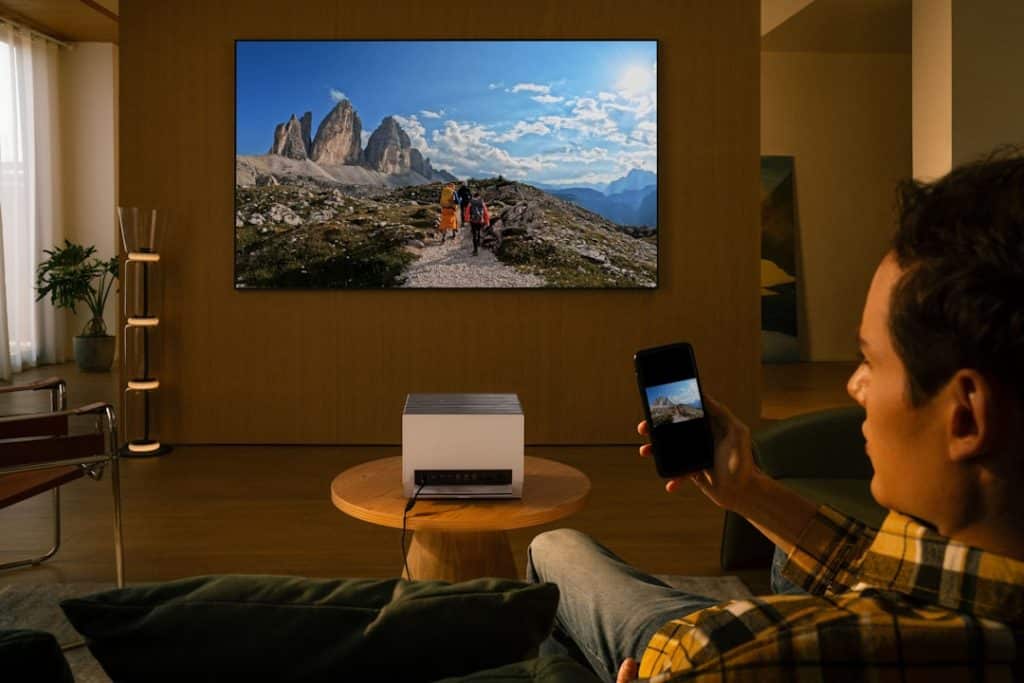 Man uses projector to display mountain landscape on wall lg smart tv paramount plus app installation - AI Bud