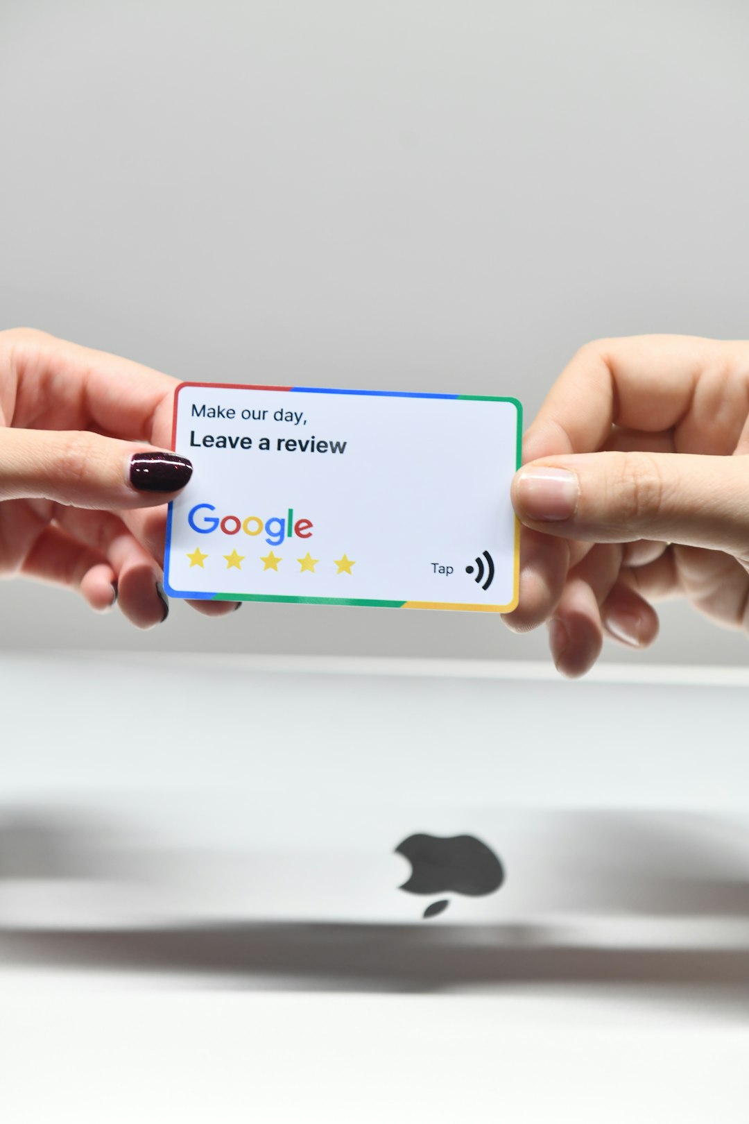 two hands holding a google credit card in front of an apple logo google verification postcard phone verification - AI Bud