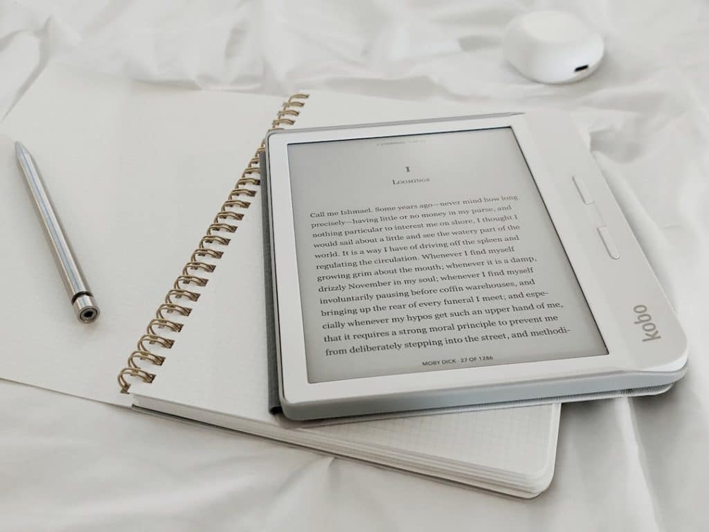 white book page on white textile ai scribe digital notebook intelligent automation - AI Bud