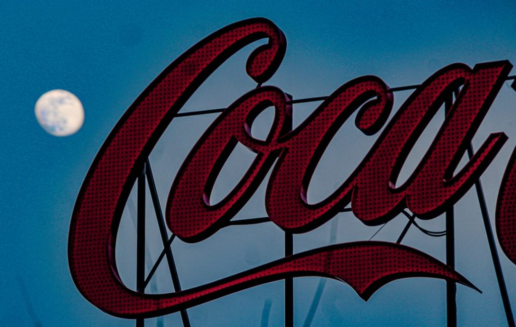 a coca cola sign with the moon in the background canva logo design ecommerce branding - AI Bud