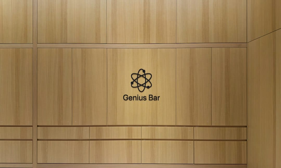 Wooden wall with a black Genius Bar sign and atom logo in the center.