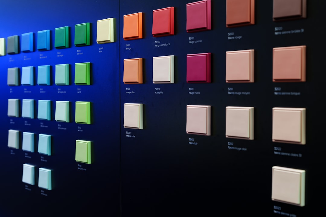 Grid of colorful square swatches on a dark wall, labeled with color names or codes.