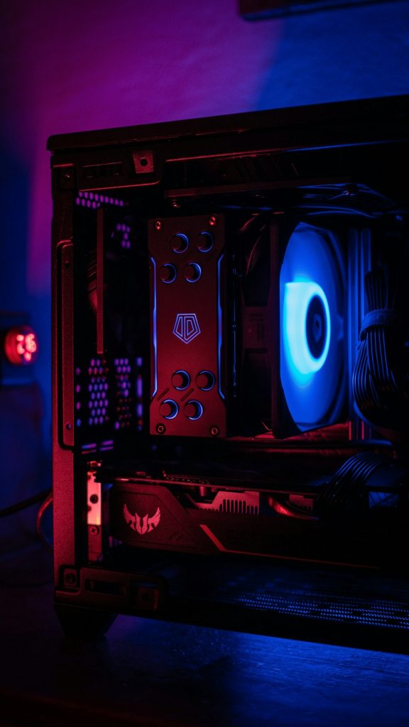 Interior of a desktop gaming PC with a bright blue case fan and red LED lighting highlighting a high-end GPU and motherboard accents