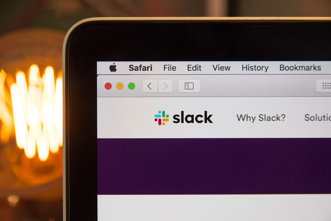 Close-up of a laptop screen showing the Slack homepage in a Safari browser on a macOS window.