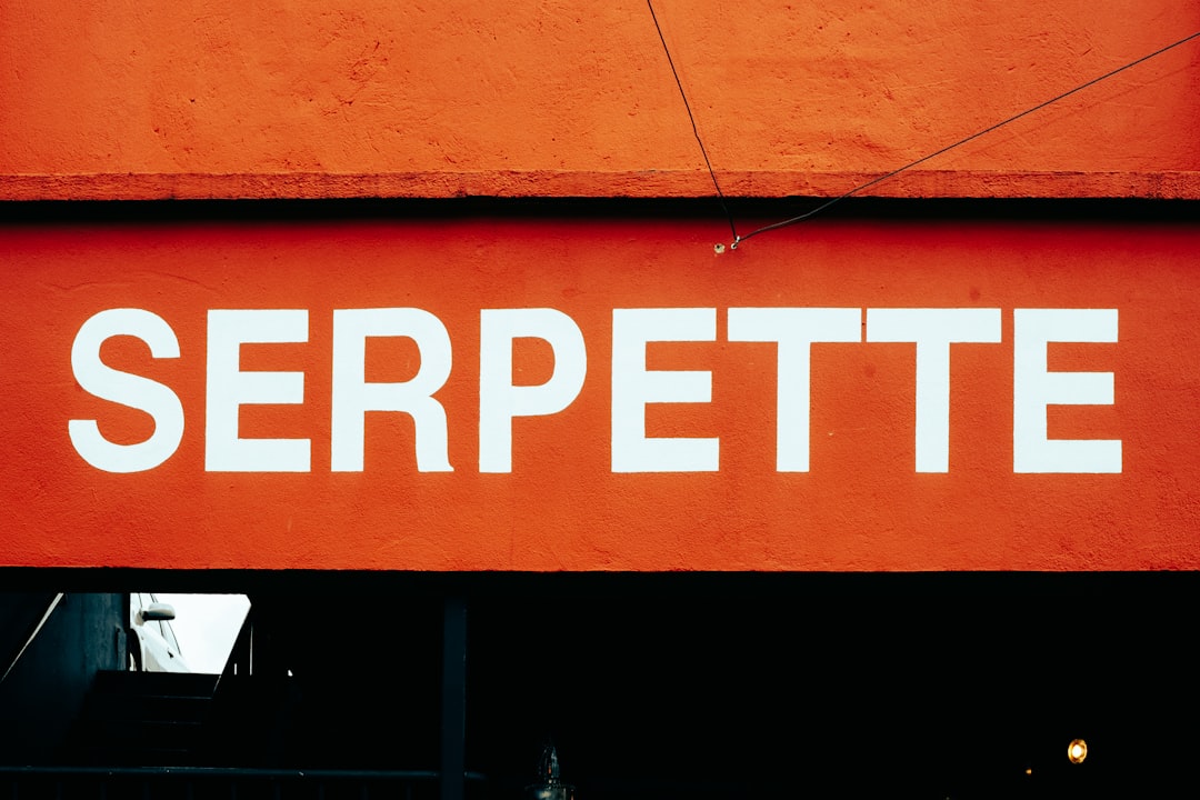 Sign on orange wall reading 'SERPETTE' in bold white letters.