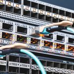 Rack of network switches with orange activity LEDs and teal Ethernet cables connected, in a data center rack