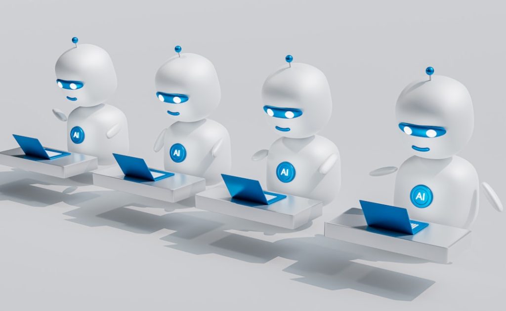 Four white AI robots sitting at desks with blue laptops, lined up and working together.