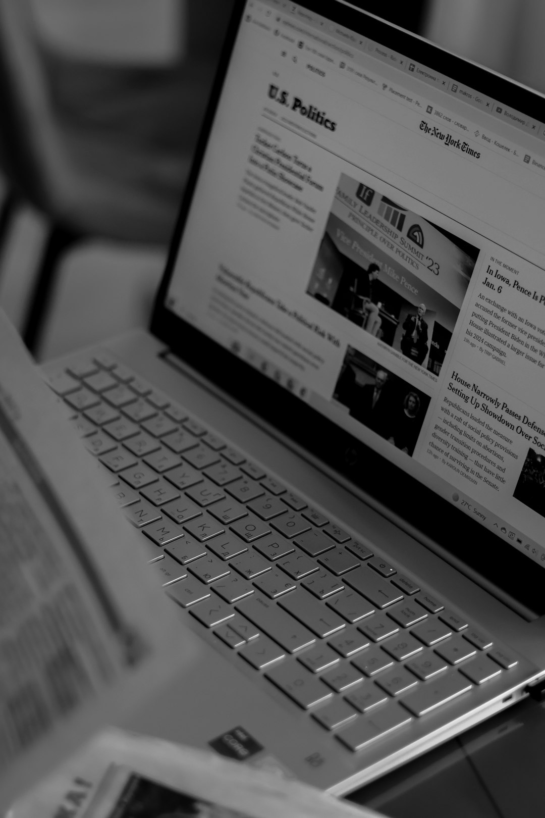 Laptop screen showing a U.S. Politics news page with headlines and images on a grayscale screen.