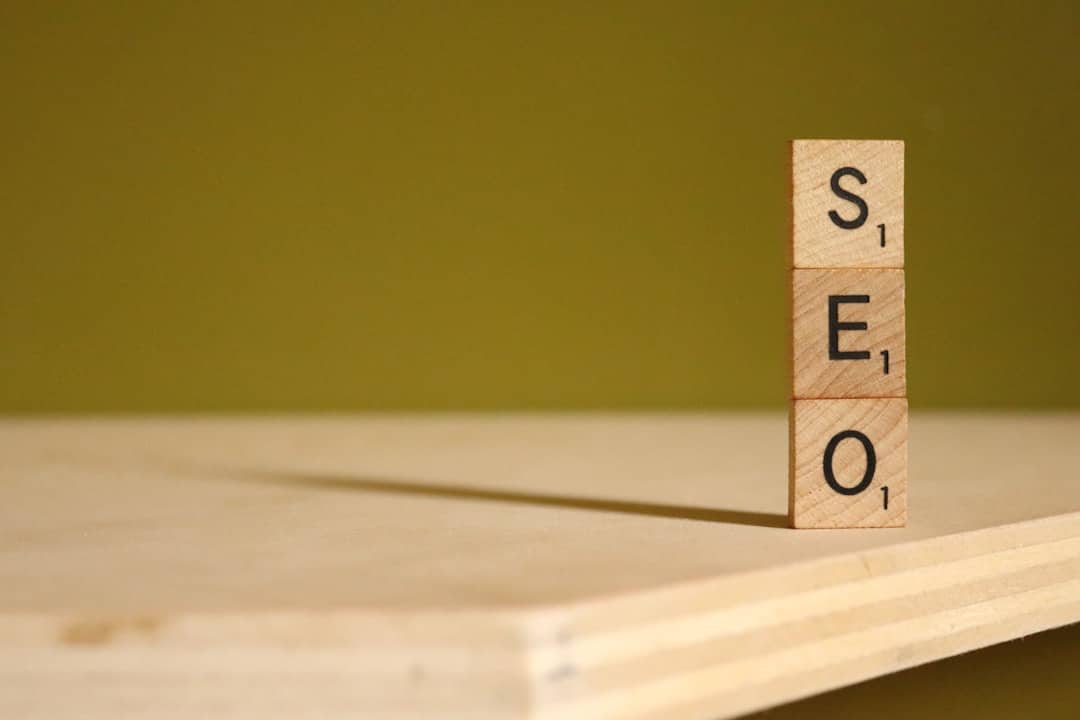 Wooden letter tiles stacked to spell 'SEO' on a table, symbolizing search engine optimization.