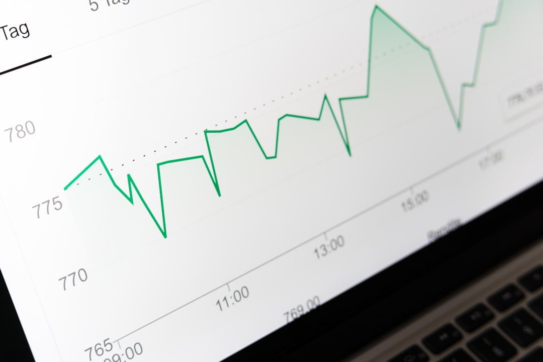 Green line chart on a laptop screen showing fluctuating data over time with axis labels and timestamps (informative visualization).**