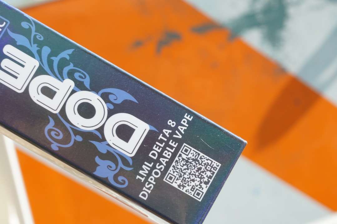 Close-up of a Delta-8 disposable vape box with a blue floral design and a QR code