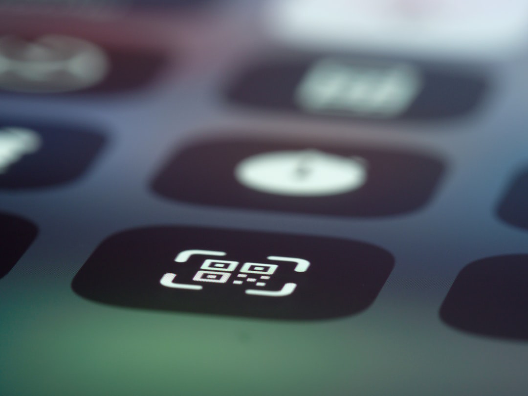 Close-up of a smartphone screen showing a white QR code icon on a dark rounded app tile amid other icons.