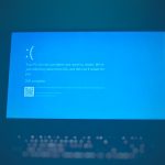 Blue Windows error screen with a sad face, 20% complete, and a QR code in the lower left area.