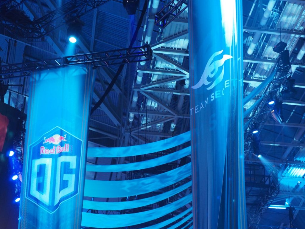 Blue banners with team logos at an esports event esports tournament setup gaming monitors competitive fortnite match arena stage - AI Bud