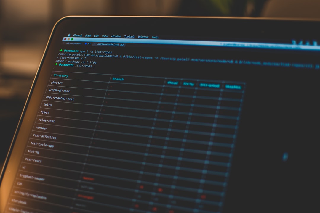 Close-up of a laptop screen showing a dark terminal with repository folders and a table of branches in blue text.
