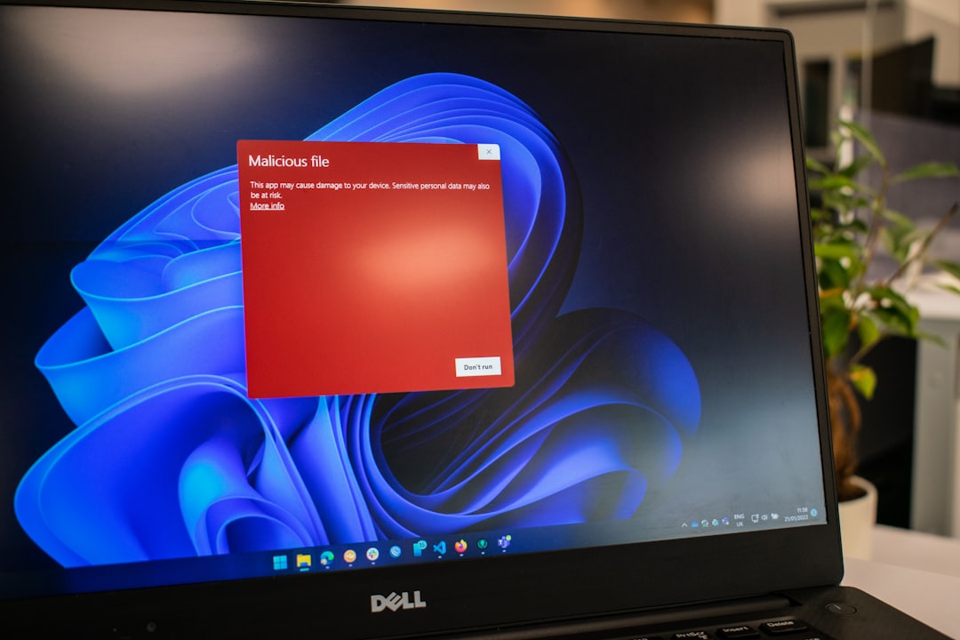 Dell laptop displaying a red 'Malicious file' warning dialog with a 'Don't run' button over a blue wallpaper.
