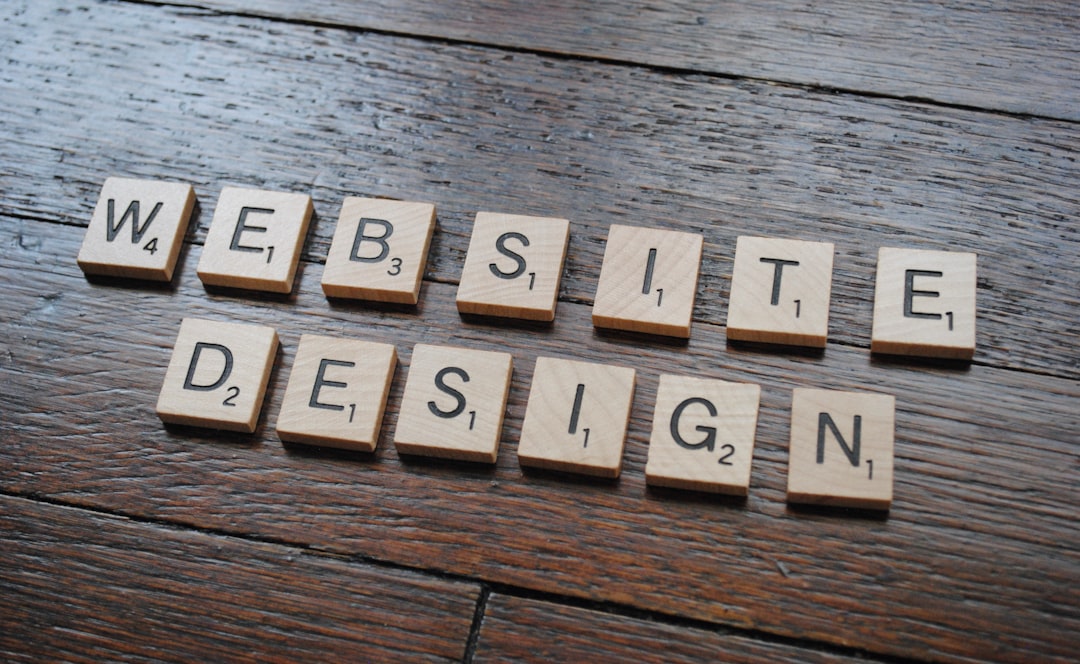 Scrabble tiles spell 'WEBSITE DESIGN' on a dark wooden table.