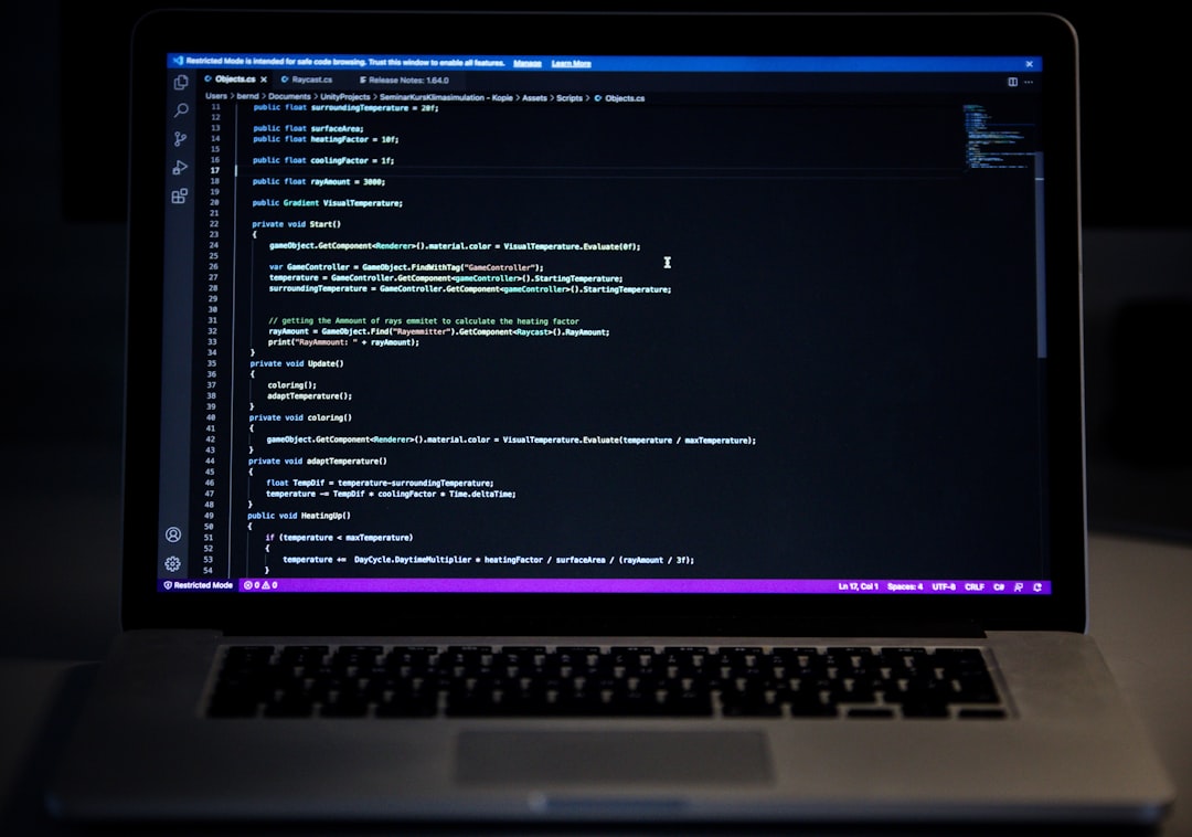 Laptop with a dark code editor open, showing C# code in Unity project.