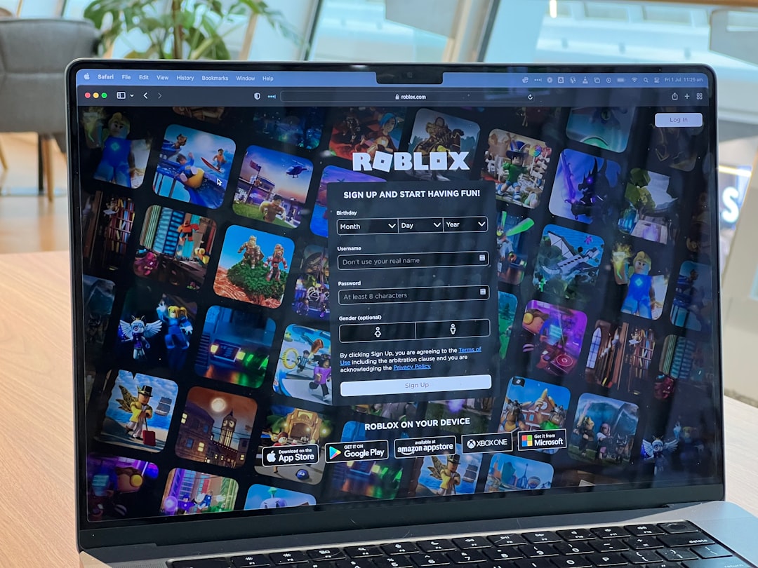 Laptop screen shows Roblox sign-up page over a collage of game thumbnails from Roblox games home screen.