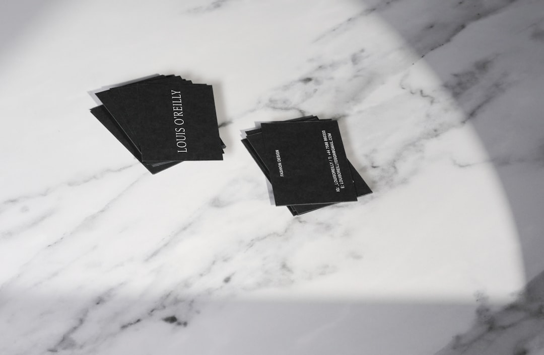 Two small piles of black business cards on a white marble surface; one card prominently reads 'LOUIS O'REILLY'.