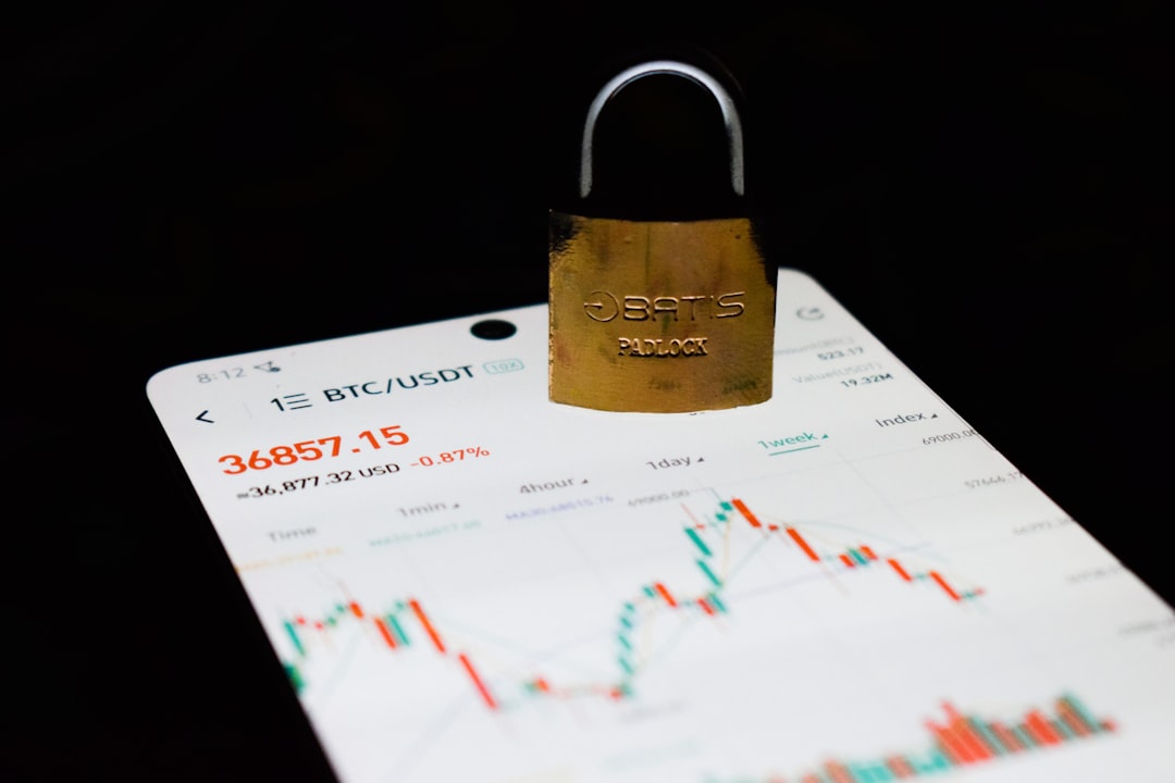 Gold padlock resting on a smartphone screen displaying a crypto trading chart, symbolizing secure crypto trading.