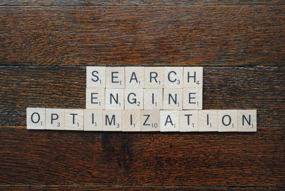 Tiles spell 'SEARCH ENGINE OPTIMIZATION' on a dark wooden surface, formed with Scrabble-style letters.