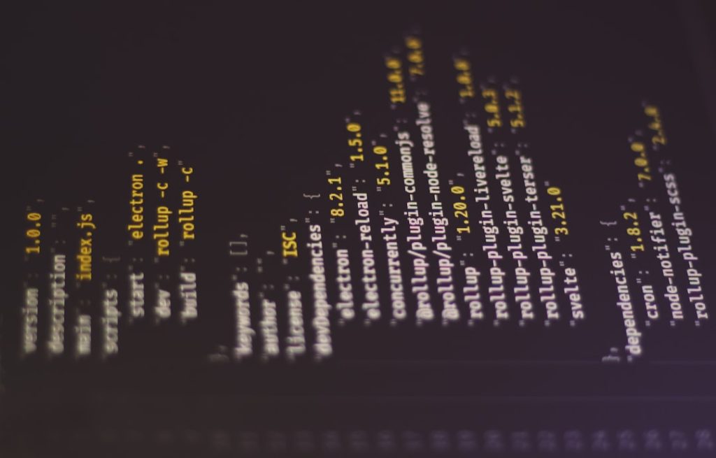 Dark terminal/console screenshot showing a vertical list of package names and versions (e.g., electron, rollup, plugin-*) in yellow and white text, rotated 90 degrees clockwise.