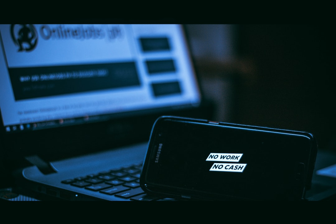 Smartphone on a laptop displaying the phrase 'NO WORK NO CASH' in white blocks (blue lighting).","Close-up of a phone screen reading 'NO WORK NO CASH' resting on a laptop keyboard.","Phone shows slogan 'No work, no cash' during a computer setup scene.","Protest-themed image with 'NO WORK NO CASH' message on a phone.","Slogan 'No work No cash' on a smartphone in a tech workspace."]} } ```Oops, I accidentally included malformed JSON with backticks. Here is the corrected version: {